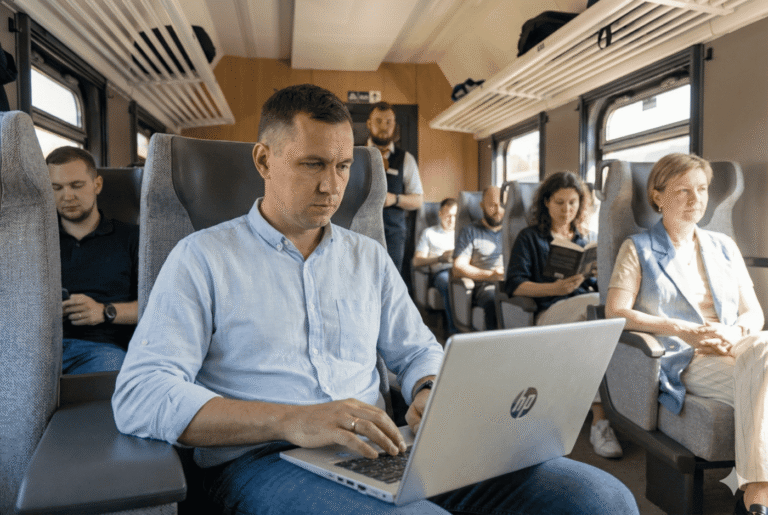 Vyras traukinyje dirba su nešiojamuoju kompiuteriu naudodamasis mobiliuoju internetu Lietuvoje